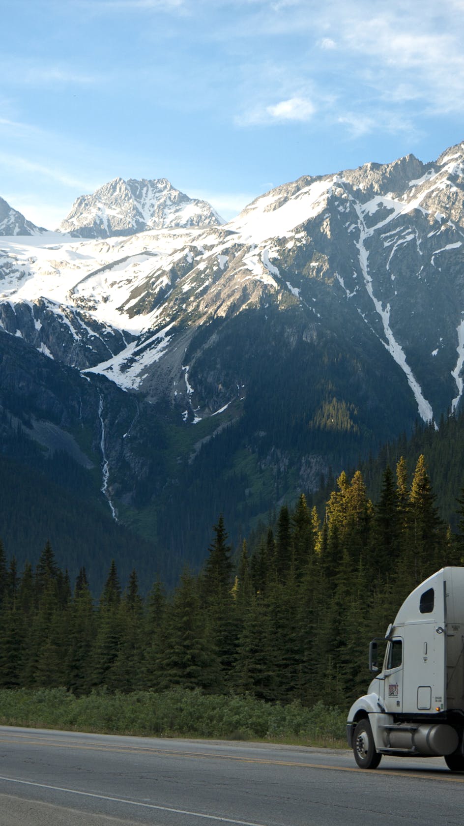 Truck climbing past snowy peaks